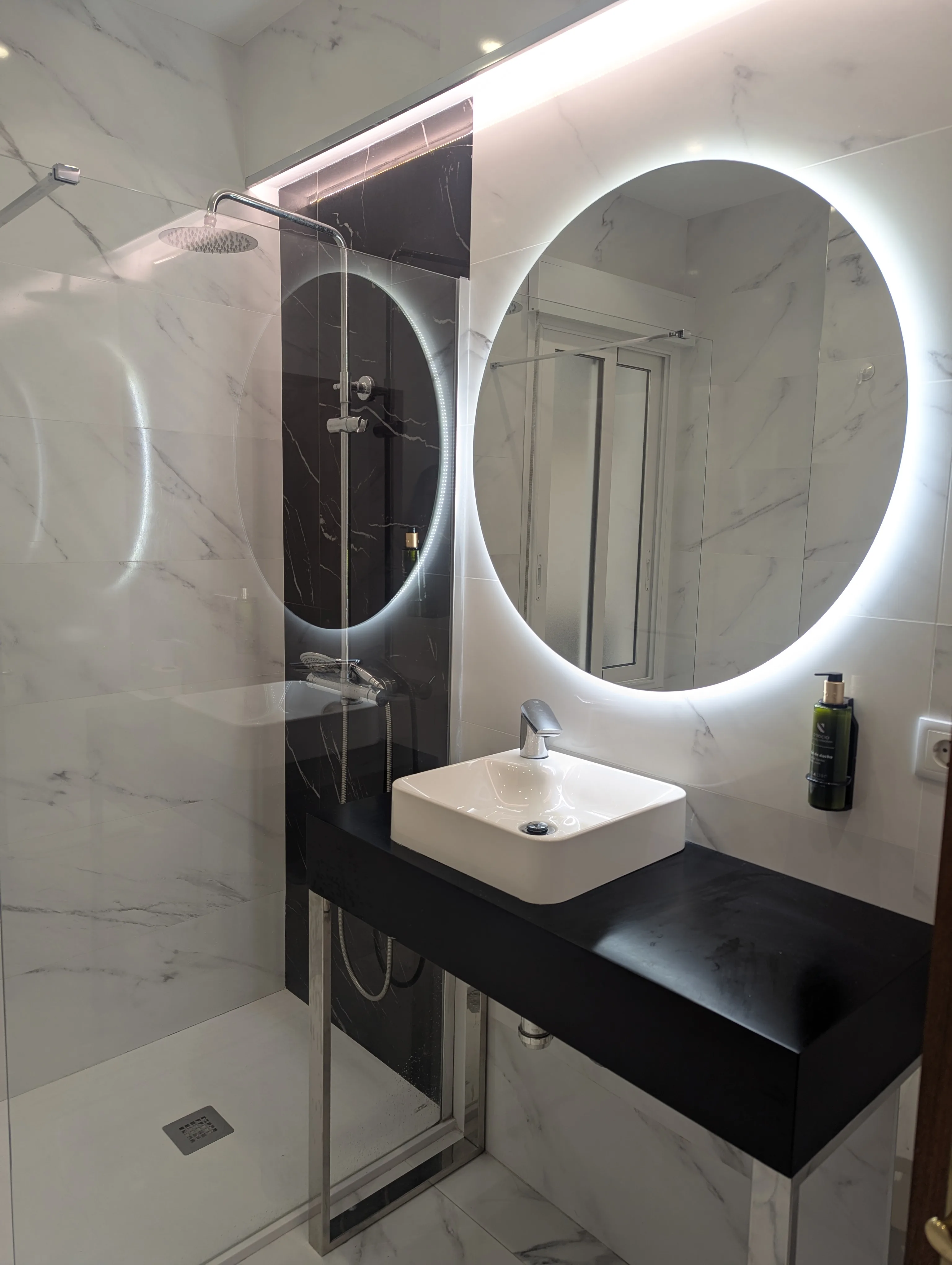 Baño con encimera negra y espejo circular en habitación doble con vistas, Hostal La Mexicana