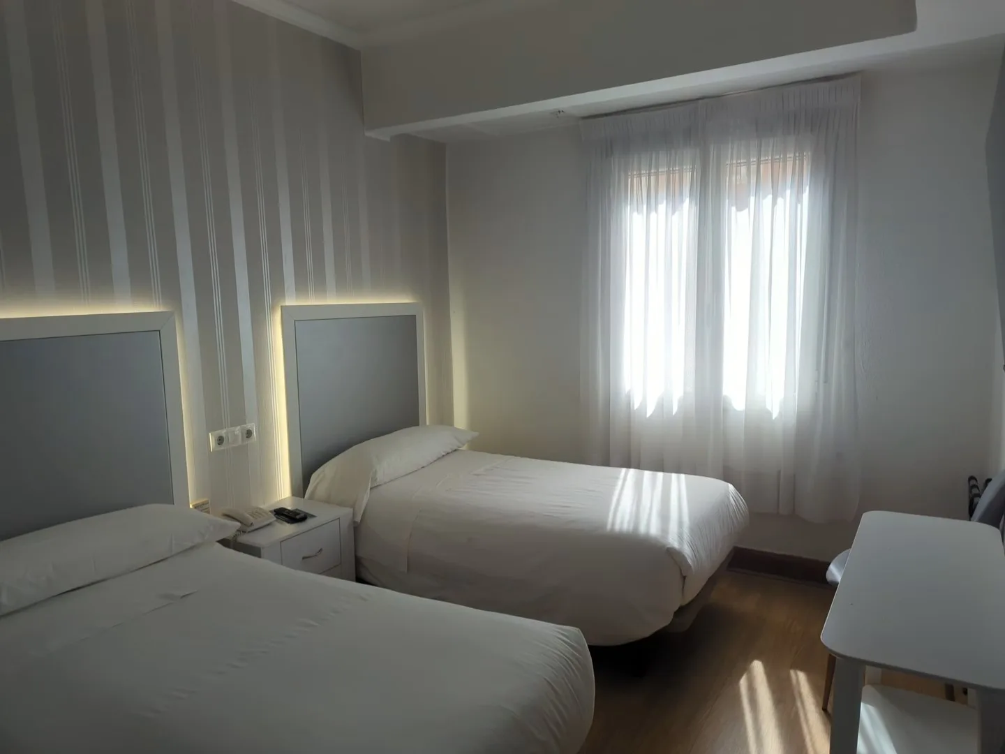 Habitación doble con vistas con cabeceros grises iluminados y gran ventana, Hostal La Mexicana Santander