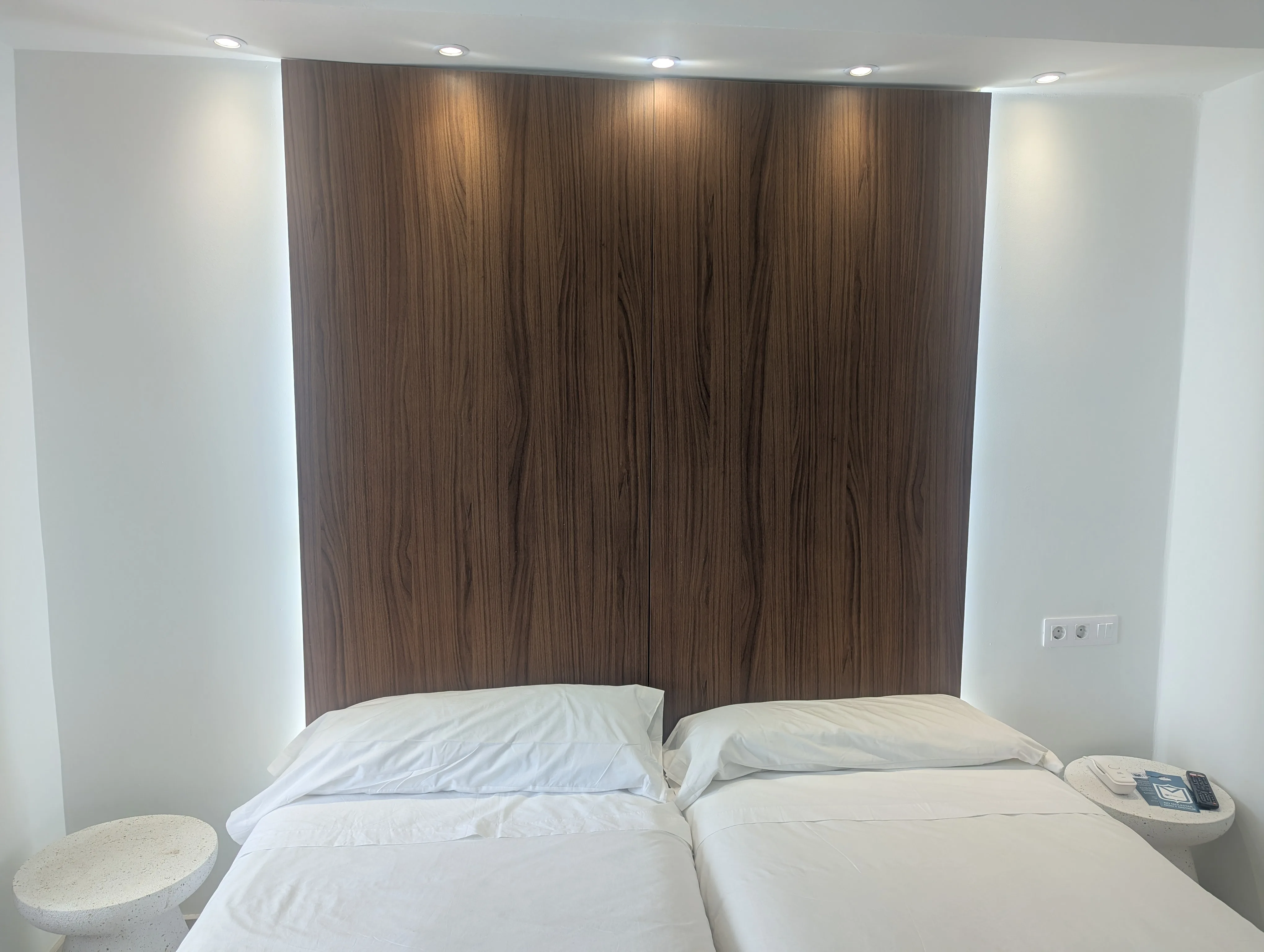 Panel de nogal a pared completa con focos de techo en habitación doble con vistas de Hostal La Mexicana Santander