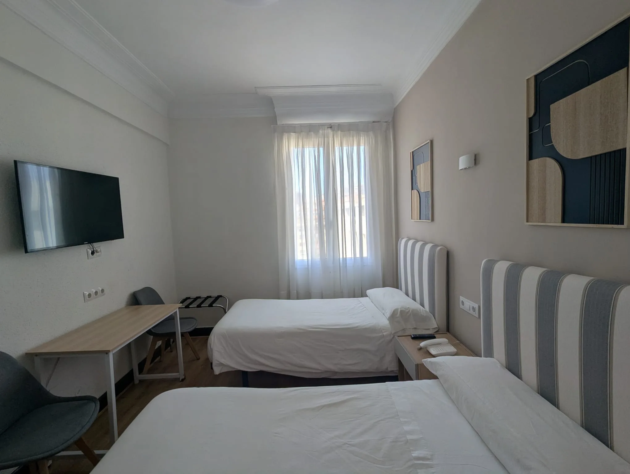 Habitación doble económica de Hostal La Mexicana Santander con dos camas individuales, Smart TV y escritorio